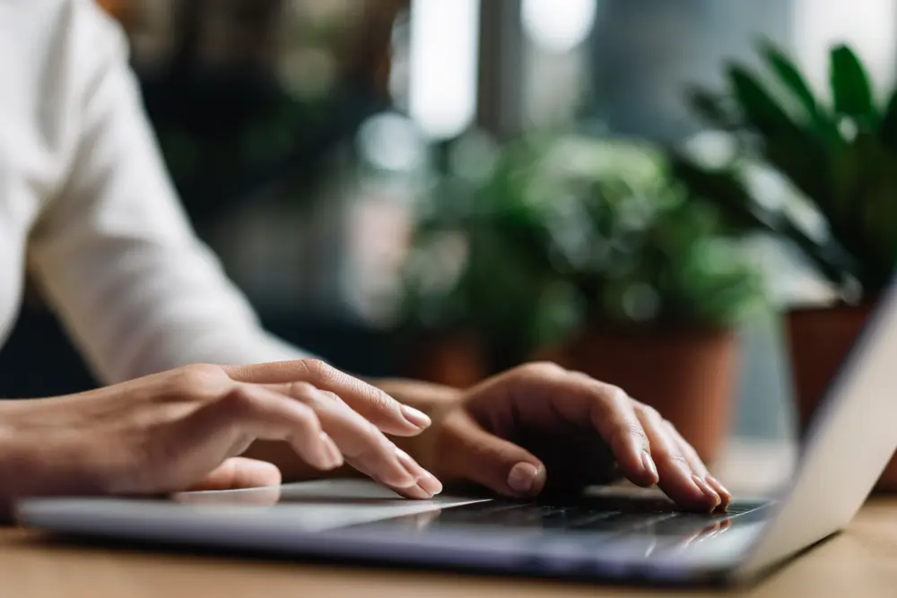 Close-up of someone typing on a laptop