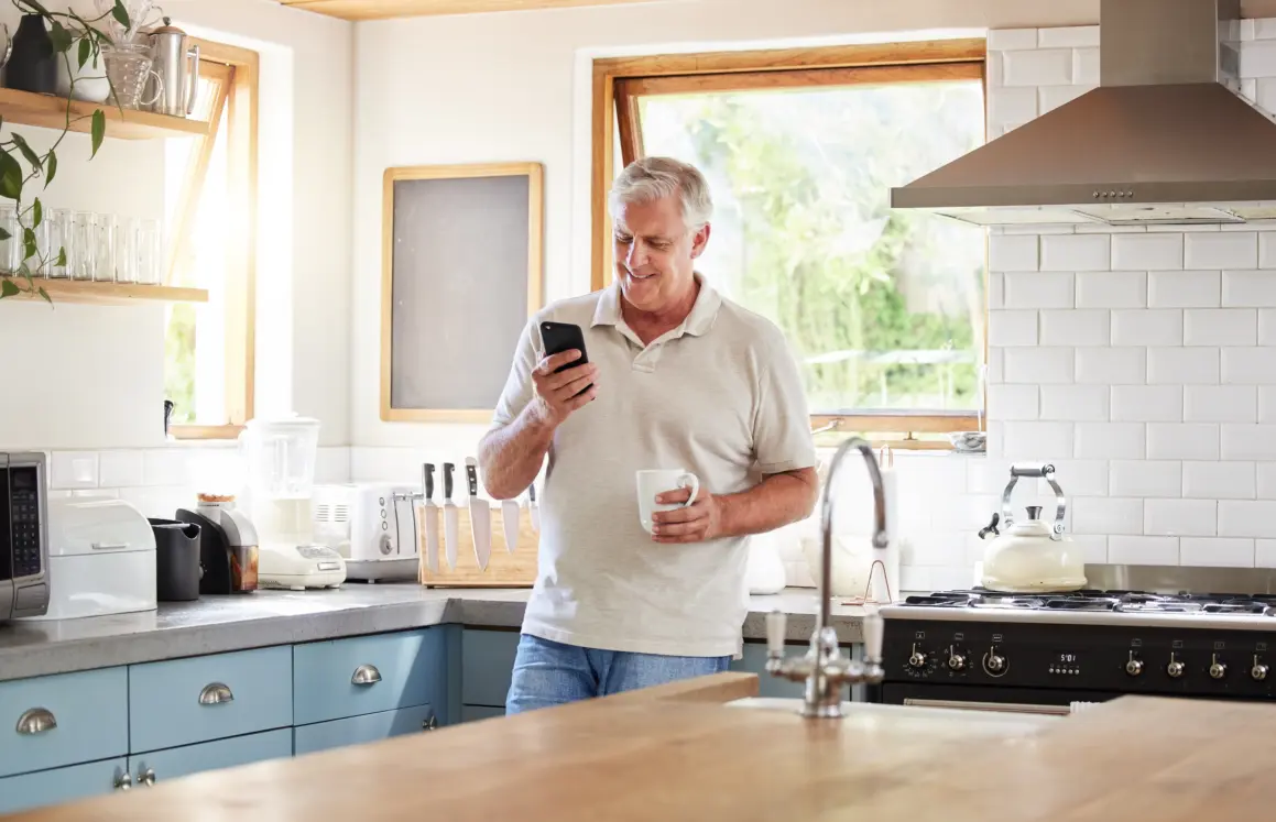 Gentleman smiling during an online therapy session on his mobile phone.